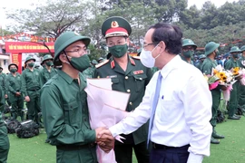 Ông Nguyễn Văn Nên, Ủy viên Bộ Chính trị, Bí thư Thành ủy Thành phố Hồ Chí Minh tặng hoa, động viên các thanh niên lên đường thực hiện nghĩa vụ quân sự tại điểm giao-nhận quân Quận 12, Thành phố Hồ Chí Minh. (Ảnh: Xuân Khu/TTXVN)