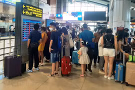 Hành khách theo dõi lịch bay của hãng hàng không tại sân bay Nội Bài. (Ảnh: Việt Hùng/Vietnam+) 