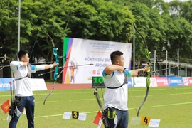 Vận động viên Nông Văn Linh (dân tộc Tày-Việt Nam) và vận động viên Nguyễn Duy (Việt Nam-phải) thi đấu nội dung cung 1 dây cá nhân nam. (Ảnh: Vũ Sinh/TTXVN)