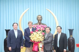 Bí thư tỉnh ủy Bến Tre Lê Đức Thọ tặng hoa Đặc phái viên của Tổng thống Hoa Kỳ về biến đổi khí hậu John Kerry. (Ảnh: Huỳnh Phúc Hậu/TTXVN)