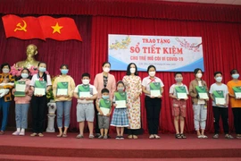 Trao sổ tiết kiệm cho trẻ em mồ côi do ảnh hưởng COVID-19 trên địa bàn thành phố Cần Thơ. (Ảnh: Trung Kiên/TTXVN)
