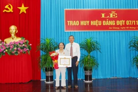 Ông Lê Văn Nưng, Phó Bí thư Thường trực Tỉnh ủy, Chủ tịch Hội đồng Nhân dân tỉnh An Giang trao Huy hiệu 60 năm tuổi Đảng cho đảng viên. (Ảnh: Thanh Sang/TTXVN)