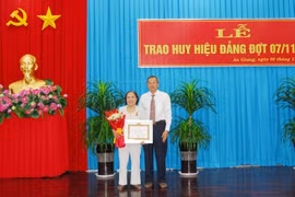 Ông Lê Văn Nưng, Phó Bí thư Thường trực Tỉnh ủy, Chủ tịch Hội đồng Nhân dân tỉnh An Giang trao Huy hiệu 60 năm tuổi Đảng cho đảng viên. (Ảnh: Thanh Sang/TTXVN)
