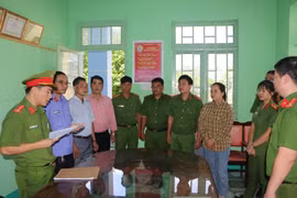 Cơ quan cảnh sát điều tra Công an tỉnh đọc lệnh bắt tạm giam bị can Trương Thị Hiệp (thứ 3 từ phải sang). (Ảnh: TTXVN phát)