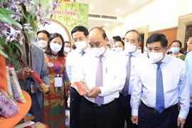 Chủ tịch nước Nguyễn Xuân Phúc thăm khu trưng bày các sản phẩm tiêu biểu của huyện Hóc Môn và Củ Chi. (Ảnh: Thống Nhất/TTXVN) 