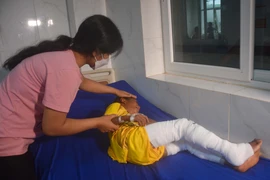 Cháu bé Y Ngách Niê, 8 tuổi, bị bỏng xăng đang được điều trị tại Bệnh viện Đa khoa vùng Tây Nguyên. (Ảnh: Hoài Thu/TTXVN)