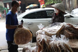 Nhiều khách du lịch đi qua đây đều dừng lại mua bánh để làm quà. (Ảnh: Danh Lam/TTXVN) 