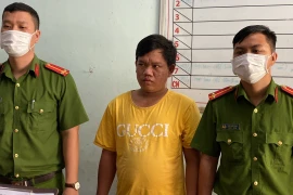 Cơ quan Cảnh sát điều tra Công an thành phố Long Xuyên (An Giang) đọc lệnh bắt đối tượng Trương Minh Hòa. (Ảnh: TTXVN phát)