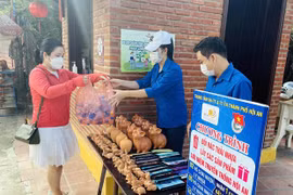 Người dân đổi rác thải nhựa lấy quà lưu niệm. (Ảnh: Trần Tĩnh/TTXVN)