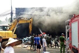 Lực lượng phòng cháy, chữa cháy và các cơ quan chức năng tỉnh Tuyên Quang nỗ lực dập tắt đám cháy. (Ảnh: Quang Cường/TTXVN)