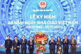 Thủ tướng Phạm Minh Chính tặng hoa chúc mừng ngành giáo dục. (Ảnh: Thanh Tùng/TTXVN)