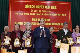 Chủ tịch nước Nguyễn Xuân Phúc tặng quà cho gia đình chính sách, người có công với cách mạng xã Quỳnh Đôi, huyện Quỳnh Lưu, tỉnh Nghệ An. (Ảnh: Thống Nhất/TTXVN) 