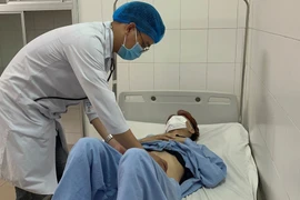 Bác sỹ thăm khám cho bệnh nhân sau can thiệp. (Ảnh: TTXVN phát)