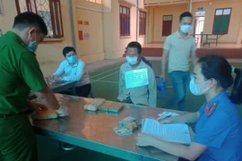 Đối tượng Giàng A Dua cùng tang vật bị thu giữ trong chuyên án tại cơ quan điều tra. (Ảnh: TTXVN phát)