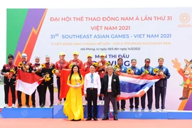 Ban tổ chức trao huy chương cho các đội nội dung thuyền 4 nữ hạng nặng chèo đơn (W4-), gồm Việt Nam (giữa - huy chương Vàng), Indonesia (trái - huy chương Bạc) và Thái Lan (phải - huy chương Đồng). (Ảnh: Minh Đức/TTXVN)