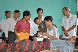 Ủy ban Mặt trận Tổ quốc Việt Nam tỉnh Quảng Ngãi trao tặng quà cho hai cha con ông Hồ Văn Thanh và Hồ Văn Lang. (Ảnh: Thanh Long/TTXVN)