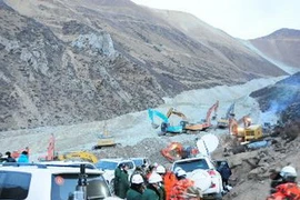 Lực lượng cứu hộ làm nhiệm vụ tại hiện trường sau vụ lở đất. (Nguồn: THX/TTXVN)