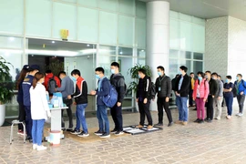 Tất cả công nhân, cán bộ, khách hàng đến làm việc tại Công ty TNHH Compal Việt Nam trong khu công nghiệp Bá Thiện 1 (huyện Bình Xuyên) đều đeo khẩu trang mới, đi qua khay dung dịch khử khuẩn, sát khuẩn tay và đo nhiệt độ để phòng chống dịch COVID-19. (Ảnh