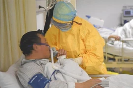 Nhân viên y tế hỗ trợ bệnh nhân nhiễm virus COVID-19 tại bệnh viện ở thành phố Trùng Khánh, Trung Quốc ngày 1/2/2020. (Ảnh: THX/TTXVN)