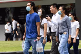 Người dân Singapore đeo khẩu trang phòng dịch viêm đường hô hấp cấp do virus COVID-19 tại quận Raffles, Singapore ngày 5/2/2020. (Ảnh: AFP/TTXVN)