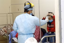 Nhân viên y tế kiểm tra thân nhiệt cho các ca bệnh đang được cách ly theo dõi nCoV tại Trung tâm Y tế Bình Xuyện (ảnh chụp chiều 7/2). (Ảnh: Dương Ngọc/TTXVN)