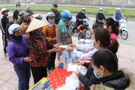 Doanh nghiệp tư nhân Anh Khoa phát khẩu trang miễn phí trên đường Lê Thái Tổ, thành phố Ninh Bình. (Ảnh: Đức Phương/TTXVN)