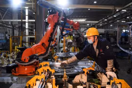 Công nhân làm việc bên trong một nhà máy ở Du Bắc, tỉnh Trùng Khánh, Trung Quốc. (Ảnh: THX/TTXVN)