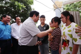 Thủ tướng Phạm Minh Chính thăm, tặng quà cho công nhân đang ở trọ tại thôn An Định, xã Tiền Phong, huyện Yên Dũng.(Ảnh: Dương Giang/TTXVN)