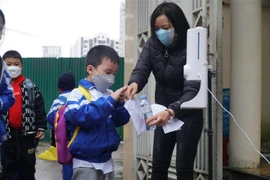 Chuẩn bị nước rửa tay sát khuẩn cho học sinh trước khi vào lớp học. (Ảnh minh họa. Nguồn: TTXVN)