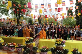 Hòa thượng Thích Tịnh Quang, Đại đức Thích Pháp Nhẫn cùng các Phật tử tại Đại lễ Phật Đản ở chùa Phổ Đà. (Ảnh: Phương Hoa/TTXVN)