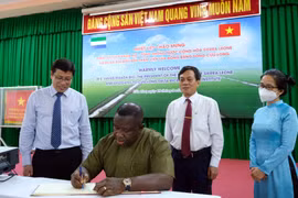 Tổng thống Cộng hòa Sierra Leone Julius Maada Bio viết sổ lưu niệm tại Viện Lúa Đồng bằng sông Cửu Long. (Ảnh: Thanh Liêm/TTXVN)