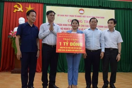 Bí thư Đảng ủy Khối các cơ quan Trung ương, ông Huỳnh Tấn Việt (thứ 2 từ trái) trao bảng tượng trưng 1 tỷ đồng hỗ trợ tỉnh Bình Định xây dựng 20 căn nhà cho hộ nghèo, chính sách. (Ảnh: Kha Phạm/TTXVN)