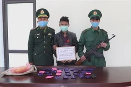 Đối tượng Lù A Thái bị bộ đội biên phòng Thanh Hóa bắt giữ cùng tang vật. (Ảnh: TTXVN phát)