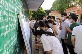 Các thí sinh xem thông tin số báo danh tại điểm thi Trường Trung học phổ thông A Phủ Lý. (Ảnh: Đại Nghĩa/TTXVN)