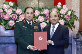Chủ tịch nước Nguyễn Xuân Phúc trao quyết định thăng quân hàm Thượng tướng cho ông Phùng Sĩ Tấn. (Ảnh: Thống Nhất/TTXVN)