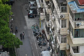 Người dân di chuyển trên một đường phố ở Thượng Hải, Trung Quốc. (Ảnh: AFP/TTXVN)