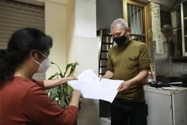 Phát giấy chứng nhận khỏi bệnh cho các bệnh nhân. (Ảnh: Minh Quyết/TTXVN)