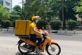 Nhân viên bưu chính vận chuyển hàng hóa. (Ảnh minh họa. Nguồn: TTXVN)