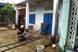 Người dân chằng, chống cửa nhà phòng chống gió bão lùa vào làm hư hỏng đồ đạc. (Ảnh: Trịnh Bang Nhiệm/TTXVN)