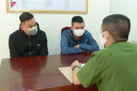 Hai đối tượng Nguyễn Anh Tuấn (trái) và Lê Văn (phải) tại cơ quan điều tra. (Ảnh: TTXVN phát)