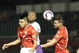 Pha tranh bóng giữa các cầu thủ đội Câu lạc bộ Thành phố Hồ Chí Minh (áo đỏ) và cầu thủ đội bóng Becamex Bình Dương (áo trắng). (Ảnh: Thanh Vũ/TTXVN)