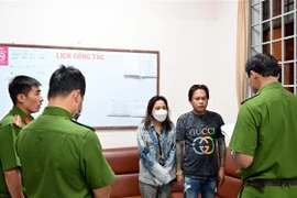 Các đối tượng nhận quyết định khởi tố và lệnh bắt tại cơ quan điều tra. (Ảnh: TTXVN phát)