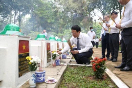 Bộ trưởng Bộ Thông tin và Truyền thông Nguyễn Mạnh Hùng thắp hương tại Nghĩa trang liệt sỹ ngành bưu điện R. (Ảnh: Thanh Tân/TTXVN)