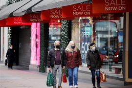 Người dân di chuyển trên một phố mua sắm ở London, Anh. (Ảnh: AFP/TTXVN)
