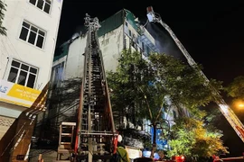 Lực lượng phòng cháy, chữa cháy dùng vòi phun nước vào khu vực có khói bốc lên. (Ảnh: Phạm Kiên/TTXVN)