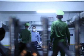 Lực lượng chức năng tới trụ sở Công ty Cổ phần Chứng khoán Trí Việt thực hiện việc khám xét. (Ảnh: Phạm Kiên/TTXVN)