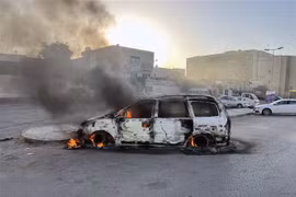 Ôtô bị đốt cháy trong các vụ đụng độ tại Tripoli, Libya, ngày 27/8. (Ảnh: THX/TTXVN)