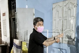 Đối tượng Thắng chỉ cánh cửa - nơi lấy chiếc máy tính bảng của hai cháu bé. (Ảnh: TTXVN phát)