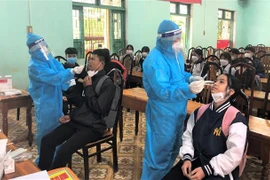 Lấy mẫu xét nghiệm nhanh kháng nguyên SARS-CoV-2 cho cán bộ quản lý, giáo viên và học sinh tại Quảng Trị. (Ảnh: Thanh Thủy/TTXVN)