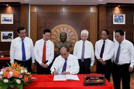 Chủ tịch nước Nguyễn Xuân Phúc viết lưu bút tại Khu lưu niệm Chủ tịch Hội đồng Nhà nước Võ Chí Công, thôn Khương Mỹ, xã Tam Xuân 1, huyện Núi Thành. (Ảnh: Thống Nhất/TTXVN)